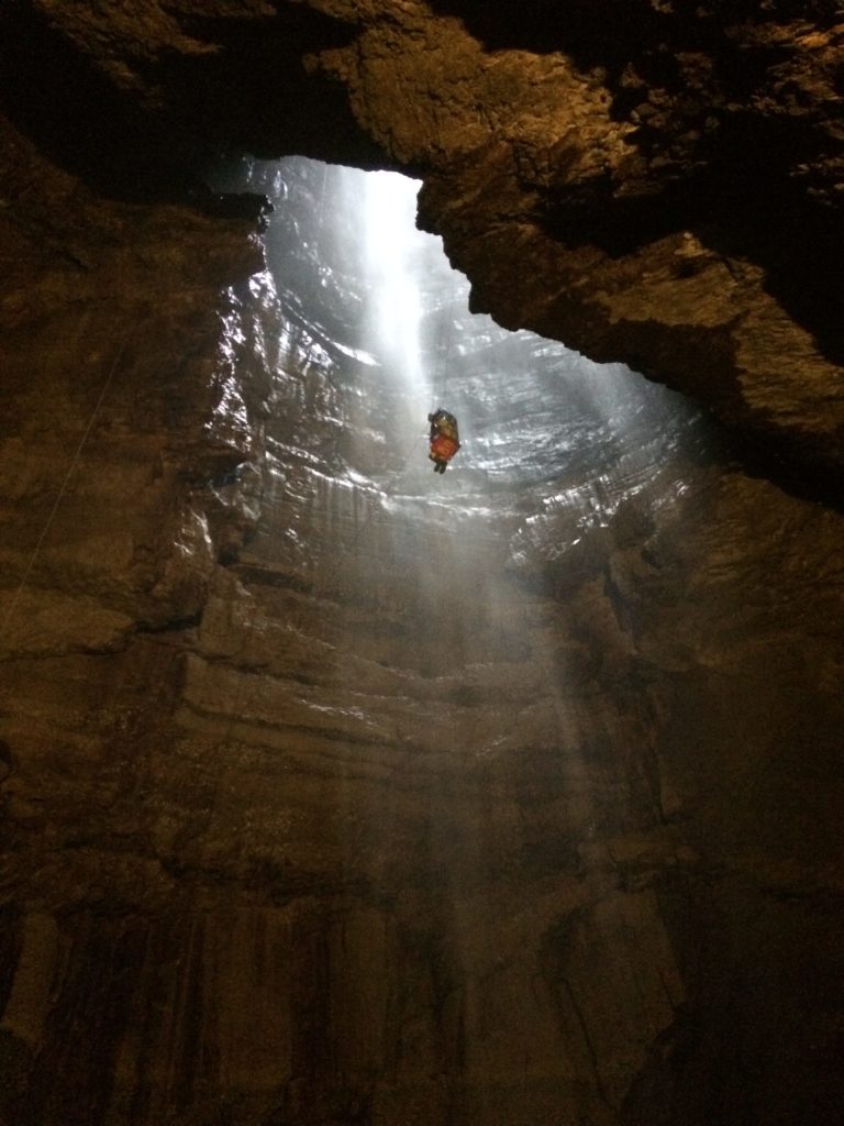 Person being lowered into cave Person being lowered into cave